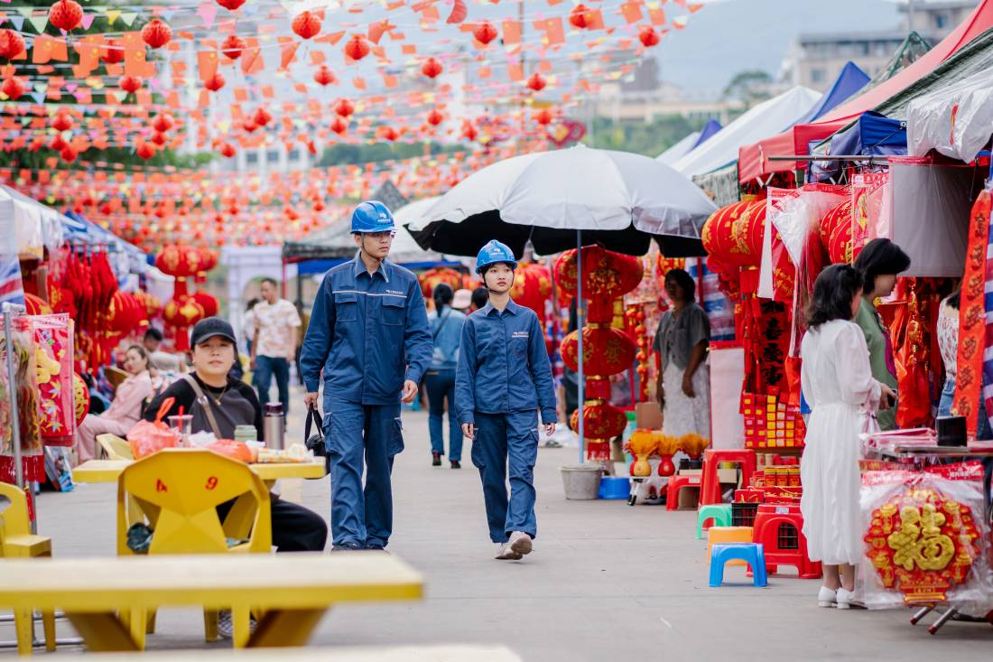 2月4日，海南省白沙黎族自治县牙叉河边上开启年货市场模式，南方电网保供电人员到现场进行用电检查，为用户讲解安全用电注意事项。（余盛本 摄）.jpg