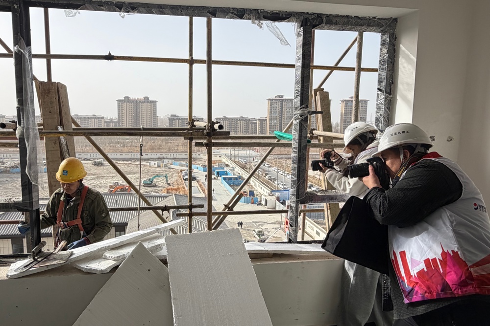 志愿者正在为工友拍摄工作照  热孜宛古丽 摄 (2)