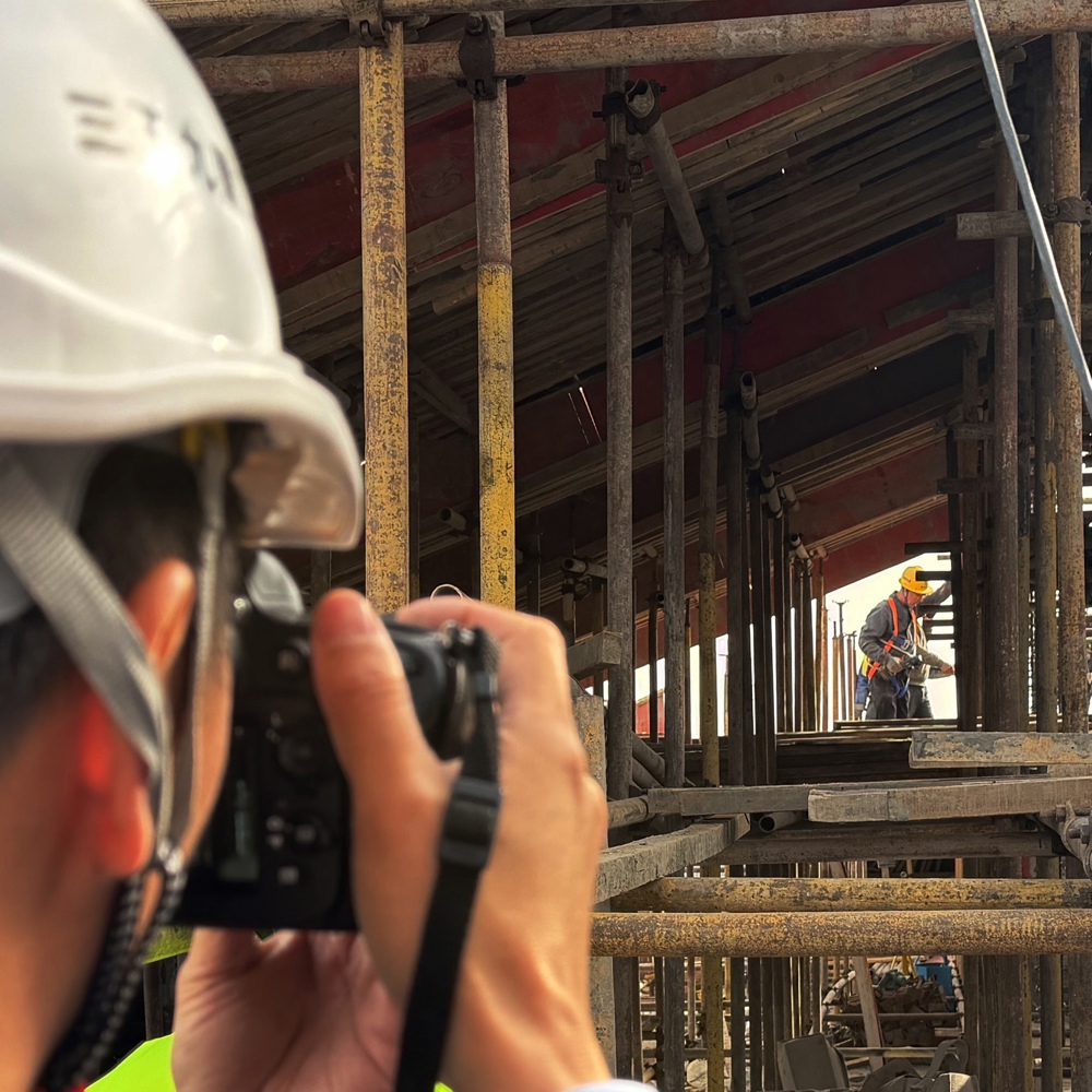 志愿者正在为工友拍摄工作照  热孜宛古丽 摄