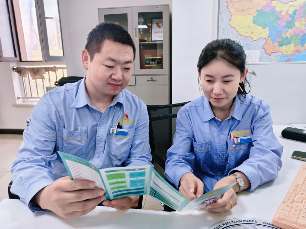 图为：职工看宣传页照片